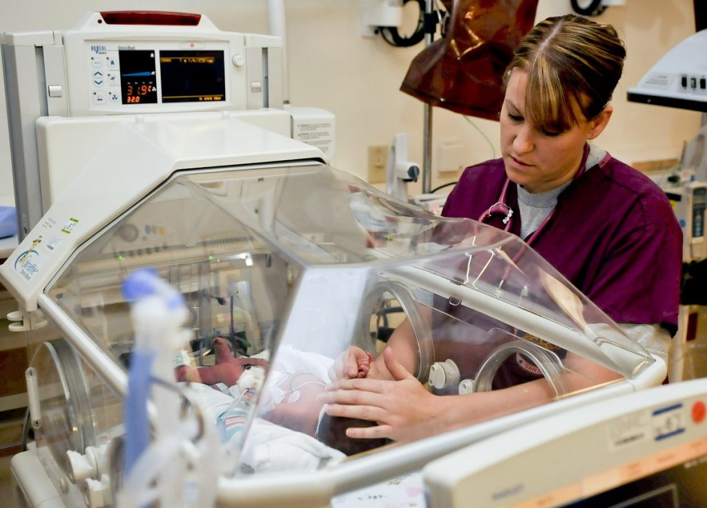 Nurse checking baby patient in ward