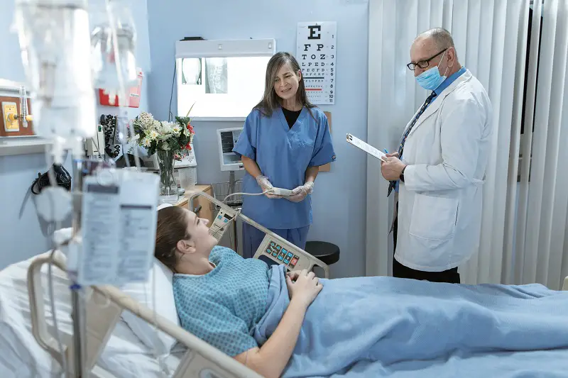 Senior Doctor and a nurse talking to the sick patient 