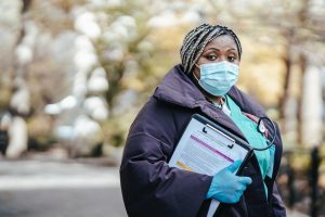 Black female Nurse in street with documents