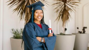 Young woman in a graduation gown holding a PSW certificate